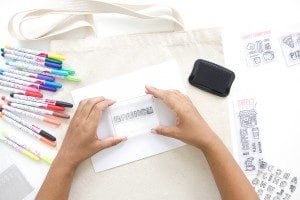 Use a few supplies to create a customized diy stamped canvas tote bag that you can color with fabric markers