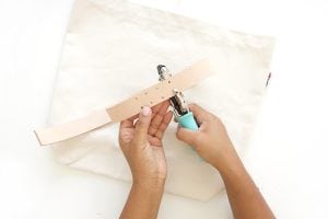 Transform a regular canvas tote bag into a DIY Leather Strap Tote Bag with the addition of leather and a few basic crafting supplies.ban