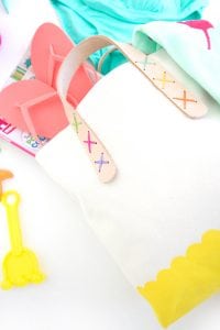 Transform a regular canvas tote bag into a DIY Leather Strap Tote Bag with the addition of leather and a few basic crafting supplies.