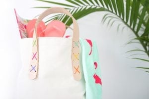 Transform a regular canvas tote bag into a DIY Leather Strap Tote Bag with the addition of leather and a few basic crafting supplies.