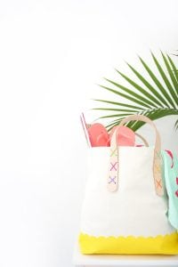 Transform a regular canvas tote bag into a DIY Leather Strap Tote Bag with the addition of leather and a few basic crafting supplies.