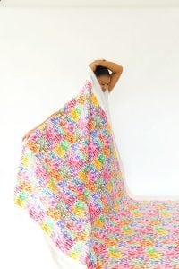 Large area rugs can be pricey! Follow this tutorial on how to turn a regular piece of fabric into a DIY Mod Podge Fabric Rug. It's totally customizable and afforable.