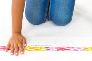 Large area rugs can be pricey! Follow this tutorial on how to turn a regular piece of fabric into a DIY Mod Podge Fabric Rug. It's totally customizable and afforable.