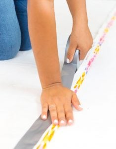 Large area rugs can be pricey! Follow this tutorial on how to turn a regular piece of fabric into a DIY Mod Podge Fabric Rug. It's totally customizable and afforable.