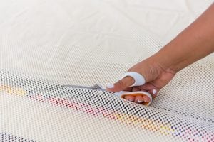 Large area rugs can be pricey! Follow this tutorial on how to turn a regular piece of fabric into a DIY Mod Podge Fabric Rug. It's totally customizable and afforable.