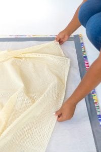 Large area rugs can be pricey! Follow this tutorial on how to turn a regular piece of fabric into a DIY Mod Podge Fabric Rug. It's totally customizable and afforable.