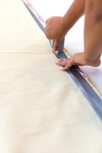 Large area rugs can be pricey! Follow this tutorial on how to turn a regular piece of fabric into a DIY Mod Podge Fabric Rug. It's totally customizable and afforable.