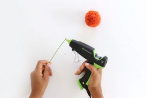Place a small bead of hot glue on the floral wire to attach pom pom